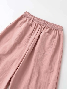 Close-up of pink casual pants featuring elastic waistband and square back pockets