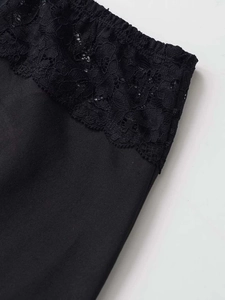Close-up of black knit skirt with delicate floral lace trim and intricate hemline detail
