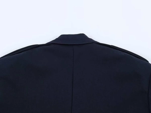 Detailed view of dark navy blazer neckline with epaulettes and heavy twill fabric texture