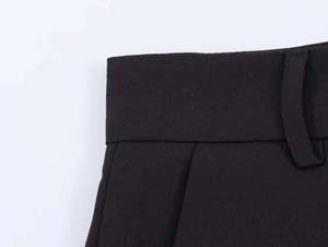 Detail shot of black trousers waist, belt loops, and side pocket with matte texture