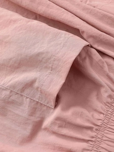 Detail of dusty rose quick-dry fabric showing a patch pocket and elasticated pleats