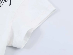 Detail of white cotton T-shirt sleeve with neat double-needle stitching and fabric texture