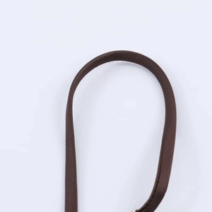 Détail macro de la sangle en tissu marron brillant avec coutures fines et texture lisse
