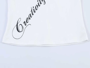 Detailed macro view of the Creativity script print on white cotton t-shirt hemline