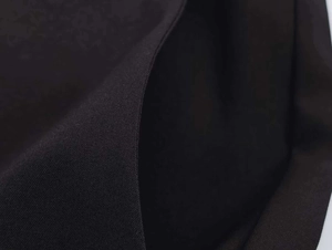 Close-up of black twill fabric texture with detailed stitching for office trousers