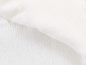 Macro shot of white knitted fabric texture showing soft ribbed pattern and fine craftsmanship