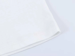 Detail of double-needle stitching and cotton fabric texture on a white t-shirt hem