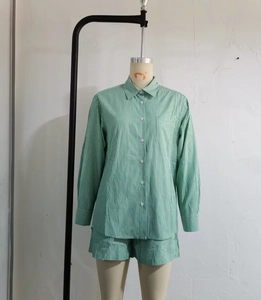 Detail view of green and white striped long-sleeve shirt and matching shorts on a mannequin