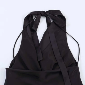 Close-up of black satin halter neck dress featuring elegant backless tie-up bow detail