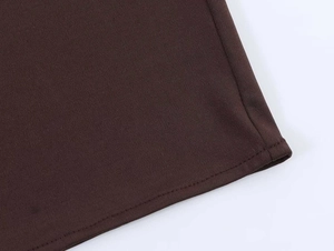 Detail view of the deep brown knitted fabric with precise double-needle flatlock stitching