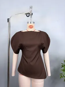 Detail view of a brown off-the-shoulder top with structured puff sleeves and curved hemline
