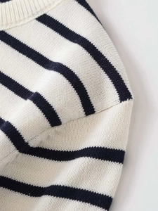 Macro shot of fine striped knit fabric with detailed ribbed neckline and modern texture