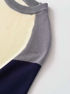 Detail shot of the ribbed crew neck and color-block knit pattern in beige grey and navy