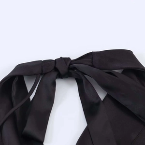 Detailed close-up of the elegant black satin bow tie design on the back of the dress
