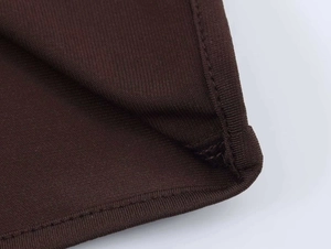 Detail shot of fine coffee brown knit fabric showing clean double-needle stitching
