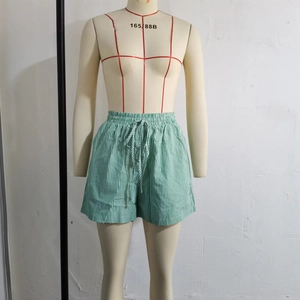 Detail of green and white vertical striped casual shorts with drawstring elastic waist