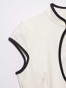 Detail of cream-white knit fabric with contrast black piping on neckline and shoulder seam
