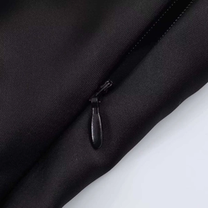 Detailed macro view of the invisible teardrop zipper on elegant black satin fabric