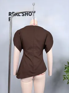 Detail shot of a dark brown short sleeve top with puff sleeves and asymmetric hem design