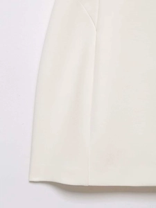 Detail shot of the hemline and vertical seam on a white modern qipao style dress