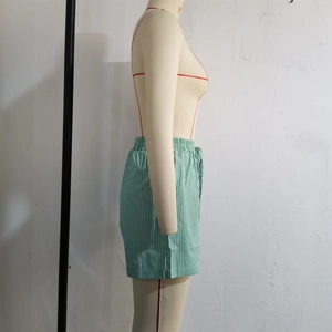 Detail of green and white striped leisure shorts with an elasticated waistband design