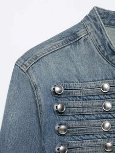 Vista detallada de chaqueta vaquera azul claro con botones metálicos y un elegante cuello alto