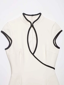 Detailed view of white cheongsam dress featuring black piping and teardrop cutout
