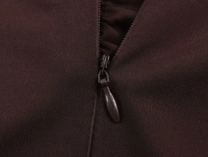 Detail view of invisible teardrop zipper on the dark brown sleeveless midi dress