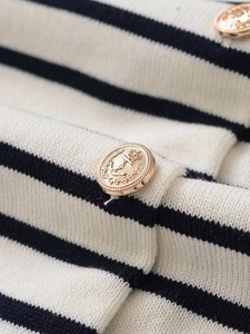 Detailed macro view of navy stripes on white knit fabric with gold nautical buttons