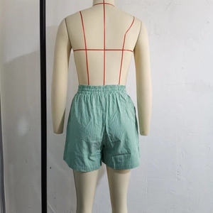 Detail of green and white vertical striped shorts with elastic waistband on a mannequin