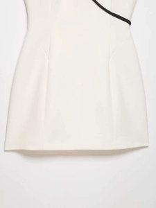 Detail view of white cheongsam dress fabric with black diagonal trim and waist stitching