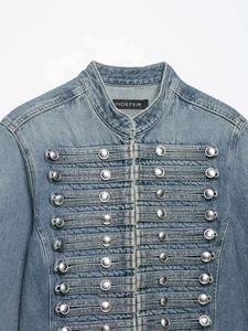 Detalle de chaqueta vaquera azul claro con botones plateados de estilo militar vintage