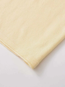 Close-up of beige knit fabric texture and high-quality flat seam stitching detail