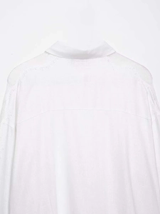 Detail of the white cotton linen shirt showing frayed fringe edges and fabric texture