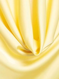 Detailed macro shot of the lemon yellow satin fabric showing smooth texture and drape