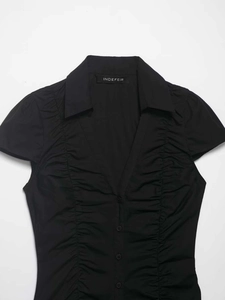Detail of black short sleeve V-neck shirt featuring ruched front and button-down closure