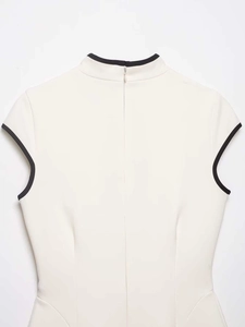 Close-up of cream cheongsam back with elegant black piping and hidden zipper detail