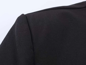 Detail of shoulder seam and tailoring on a black formal blazer with woven texture