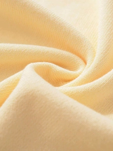 Close-up of pale yellow knit fabric texture showing fine weave and soft drape details