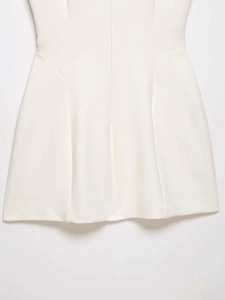 Detail view of the elegant white A-line dress hem with vertical split seams