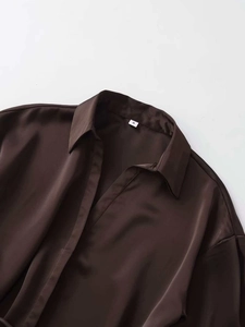 Close-up of deep coffee satin shirt collar with size S label and silky fabric texture