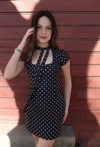Gros plan sur une robe vintage à pois avec une encolure évidée et un lien à nouer élégant