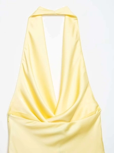 Detail of light yellow satin dress showing deep V-neckline and drape texture