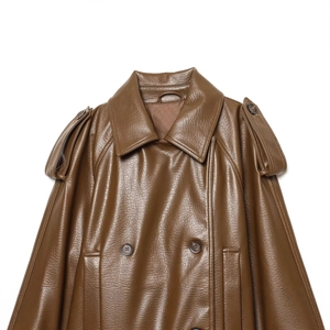 Détail de la veste en similicuir marron foncé avec boutons croisés et épaulettes