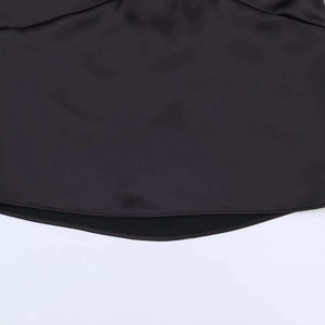 Detail of black satin fabric hem showing professional stitching and smooth texture