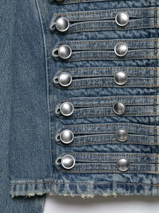 Vista detallada de la chaqueta vaquera azul vintage con botones metálicos plateados de doble botonadura