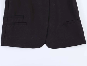 Detail of asymmetrical pockets and smooth texture on black office blazer hemline