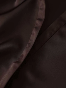 Close-up of silk satin fabric and fine stitching on a V-neck long-sleeve blouse