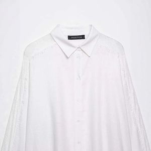 Relaxed white long-sleeved shirt featuring delicate lace stitching and fringe details