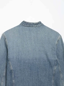 Detalle del cuello de una chaqueta vaquera azul claro con costuras amarillas en contraste